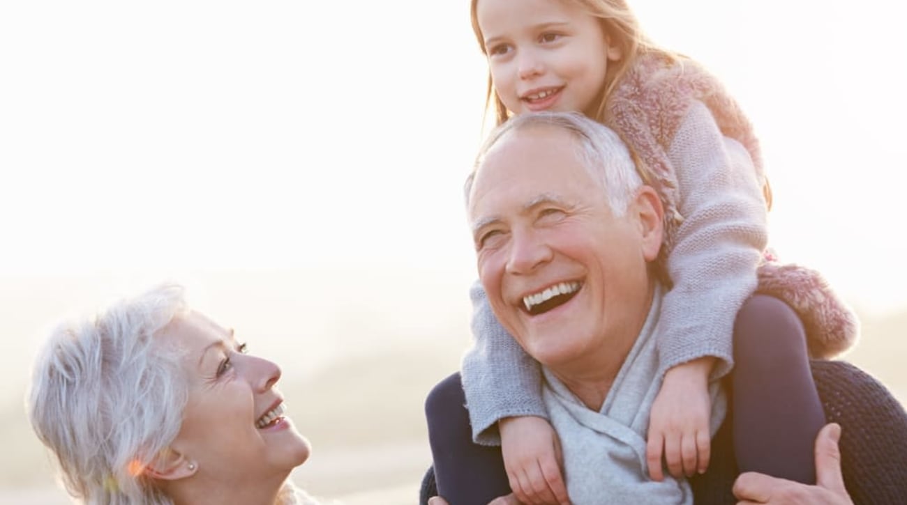 Happy resident couple and their granddaughter enjoying a day at the beach near Palo Alto Commons in Palo Alto, California