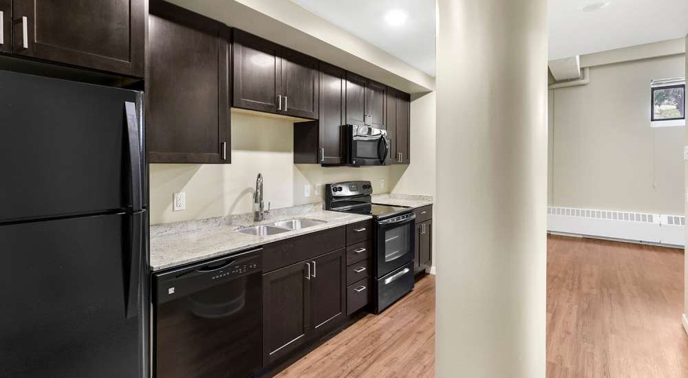 Kitchen with cabinetry and black appliances at Morada in Crystal, Minnesota