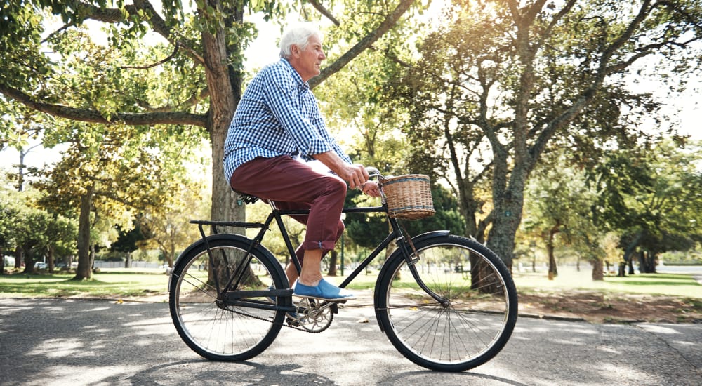 Resident riding a bicycle around one of our communities at Legacy Affordable Retirement Communities in Bellevue, Washington