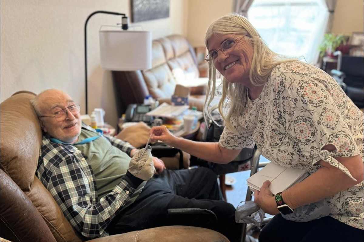 A woman assists an elderly man seated beside her at Isle at Cedar Ridge in Cedar Park, Texas.