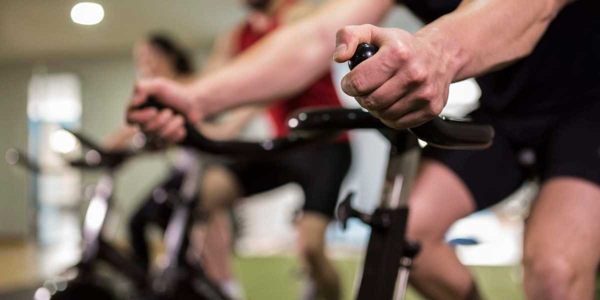 Residents doing cycling in fitness center at Ennova Highlands in Arlington, Texas