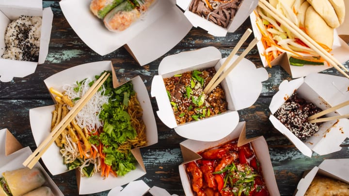 Several to-go boxes full of asian cuisine