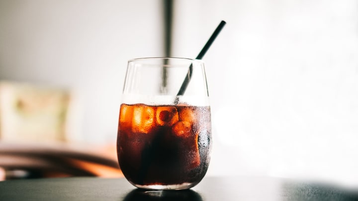 Glass of iced cold brew with a straw at Olympus Property in Fort Worth Texas