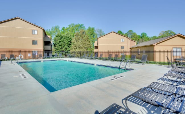 Poolside lounge chairs at Woodbrook Apartment Homes in Monroe, North Carolina