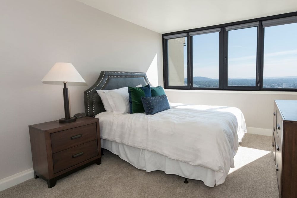 Master bedroom with large window-panes in model home at Harrison Tower in Portland, Oregon