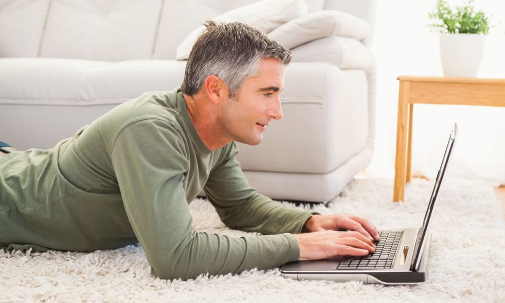 Happy resident checking out our online resources from his new apartment at Maplewood Crossing in League City, Texas