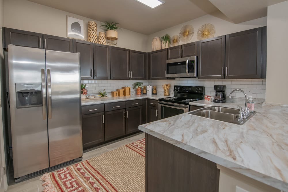 Modern kitchen with stainless-steel appliances in a model home at Redbud Ranch Apartments in Broken Arrow, Oklahoma