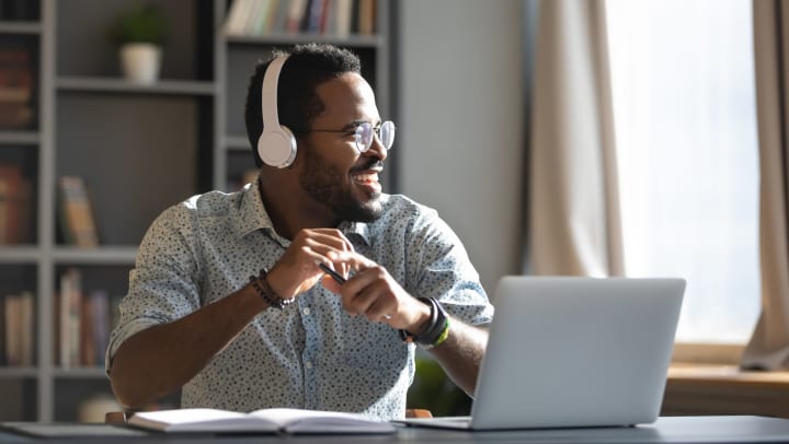 Man wearing headphones, sitting in home office