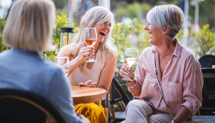 Residents drinking wine and laughing together at The Springs at Mill Creek in The Dalles, Oregon