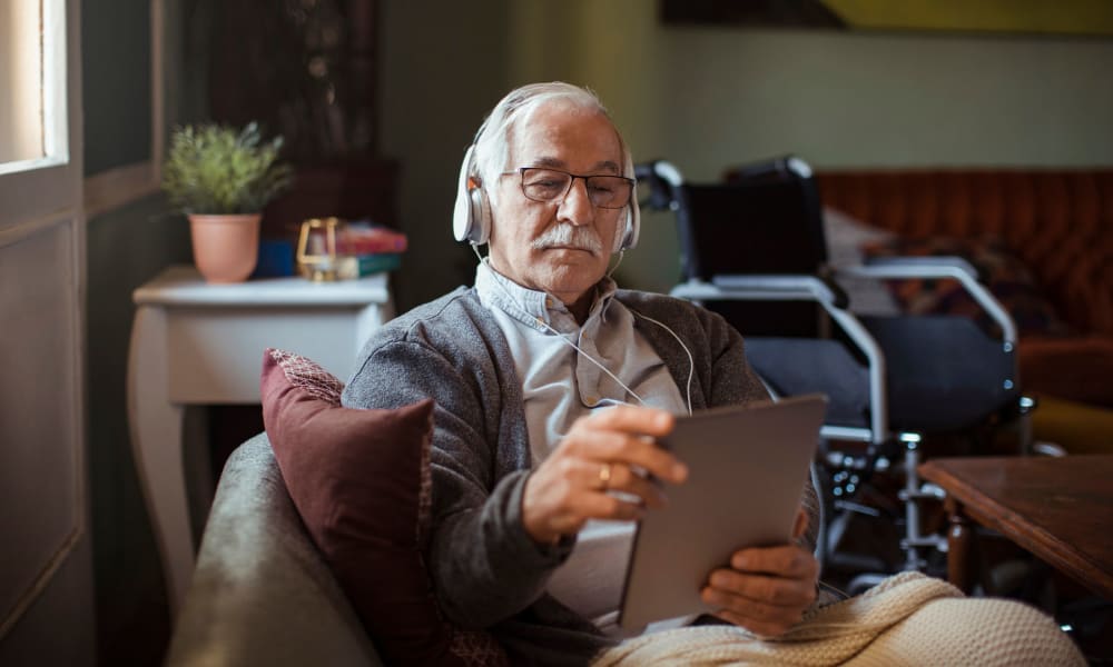 Resident listening to music through a tablet at a Jaybird Senior Living community