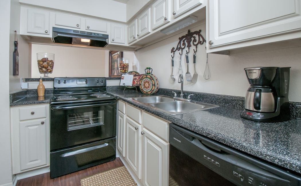 Gourmet kitchen white cabinetry and granite countertops in model home at Grayson Ridge in North Richland Hills, Texas