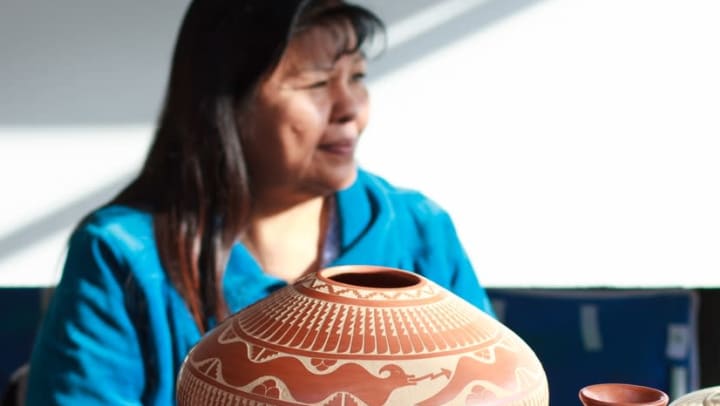 Woman showcasing North American Indigenous pottery art