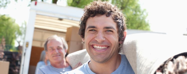 Men carrying a rolled up carpet to be stored at Bay Area Self Storage