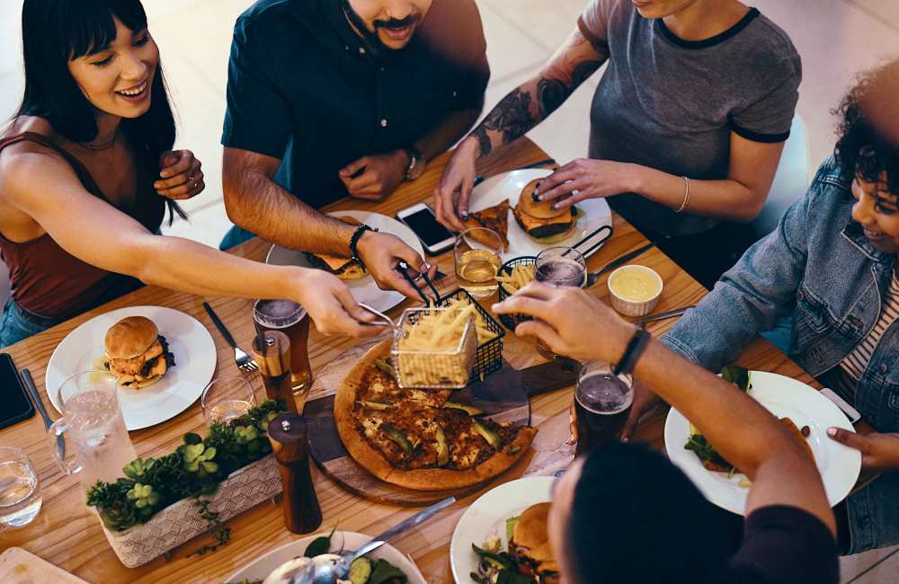 A group of friends sharing a meal in a restaurant near Douglas Park in Compton, California