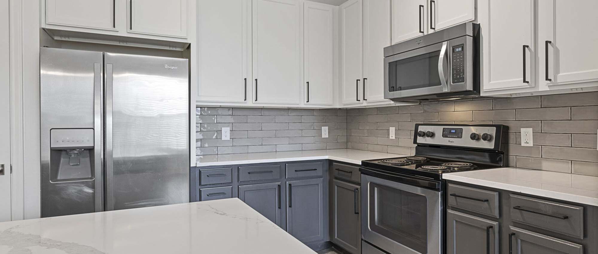Kitchen with side by side refrigerator at  Ashwood in Pflugerville, Texas