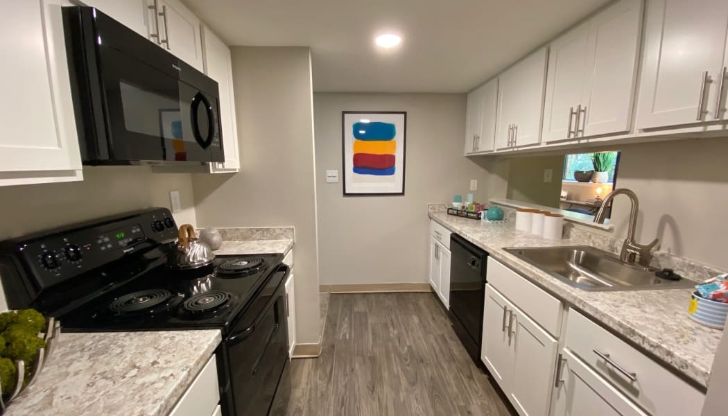 Modern kitchen with white cabinets in a model home at The Chimneys of Cradlerock Apartments in Columbia, Maryland