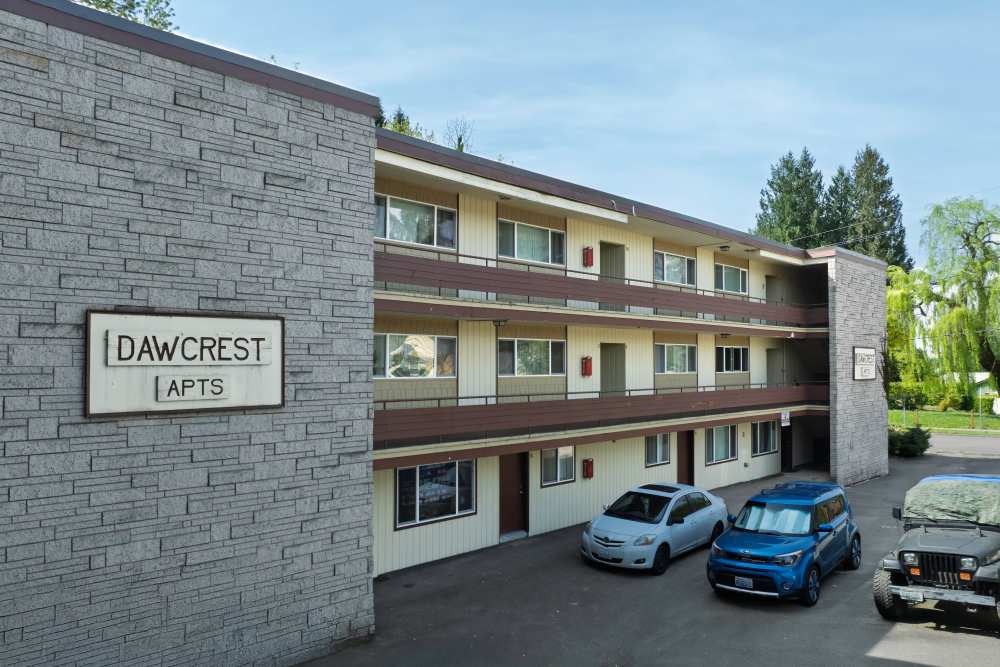 Exterior view of the apartment building with cars parked in front of the bbuilding at Dawcrest Apartments in Olympia, Washington