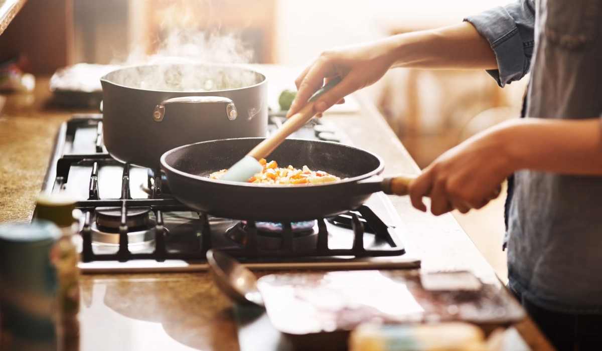 Resident preparing food in kitchen at Pine Cove Apartments in Oregon, Wisconsin