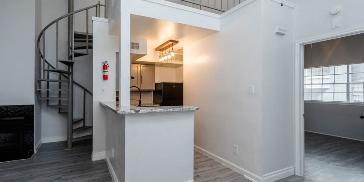 Modern kitchen with wooden cabinets, refrigerator and granite countertops at Pine Lake Village in Houston, Texas