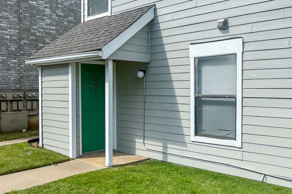 External view of an apartment with well-trimmed lawn at Savannah Square & Savannah Harbor in Norman, Oklahoma