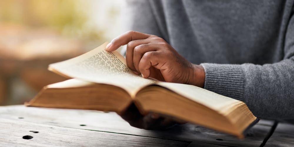 Hands Holding Bible  at Vista Prairie at Goldfinch Estates in Fairmont, Minnesota