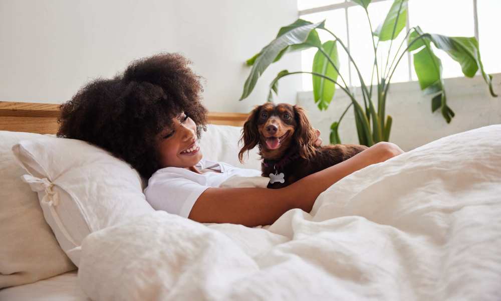 Resident with her dog in the bedroom at Fountains at Mooresville Town Square in Mooresville, North Carolina 