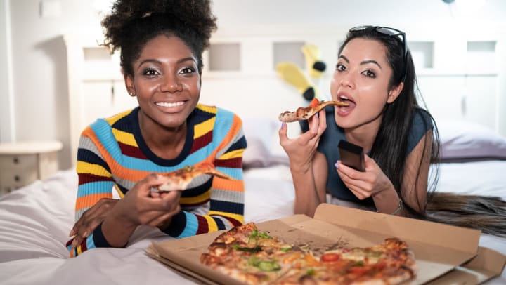 Resident friends enjoying some pizza in their new home at Olympus Sierra Pines in The Woodlands, Texas