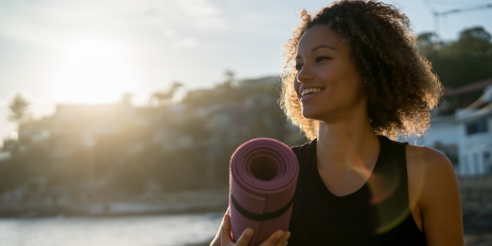 A resident carrying a yoga mat at Indigo Champions Ridge in Davenport, Florida