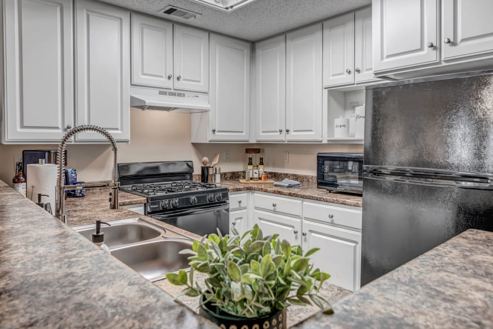 White cabinets and appliances in an apartment kitchen at Adrian On Riverside in Macon, Georgia