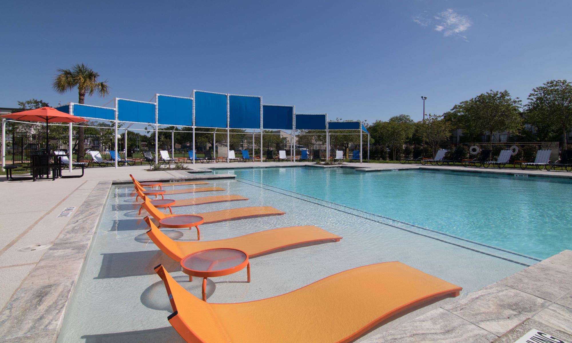 Beautiful swimming pool with tanning chairs at 2111 Holly Hall in Houston, Texas