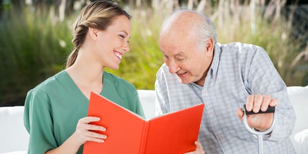 Resident reading with a caregiver at The Residences on Forest Lane in Montello, Wisconsin