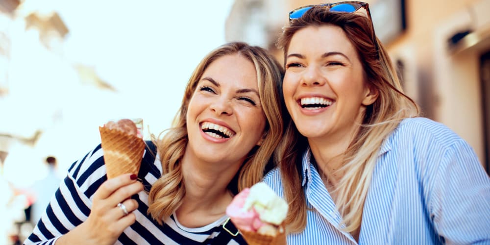 Two residents happily enjoying some ice cream near  Ellington Apartments in Davis, California