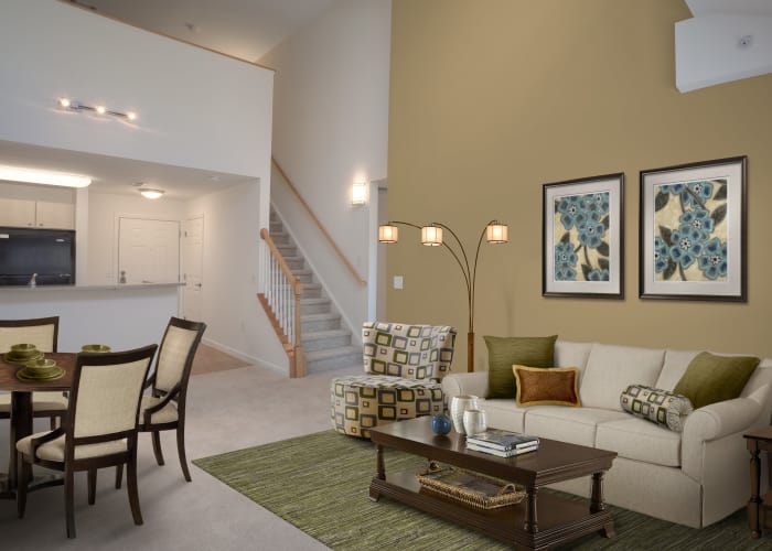 Well-decorated living room and dining area in model townhome at Prynne Hills in Canton, MA