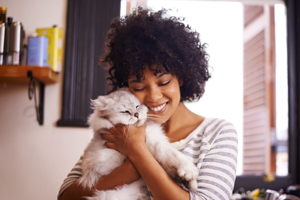 Resident holding her cat in their home at Artisan Living North Beach in Santa Rosa Beach, Florida