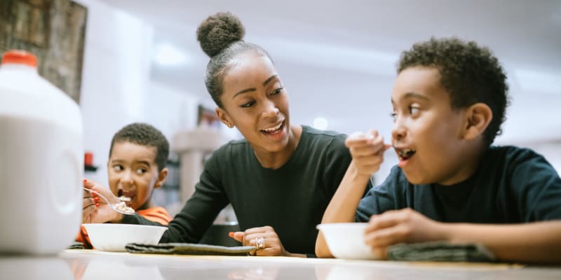 A mother and her children eating in a home at Fairway Heights in Twentynine Palms, California