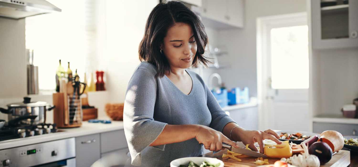 Resident preparing food in her modern kitchen at Knollview Apartments in Ovid, Michigan