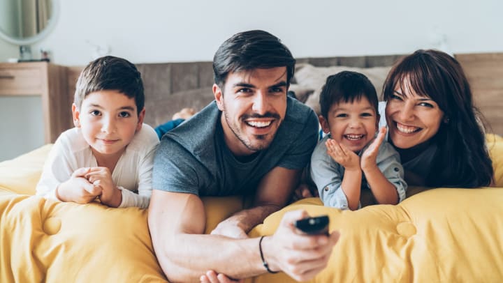 Family watching TV together at Olympus at the District in South Jordan, Utah