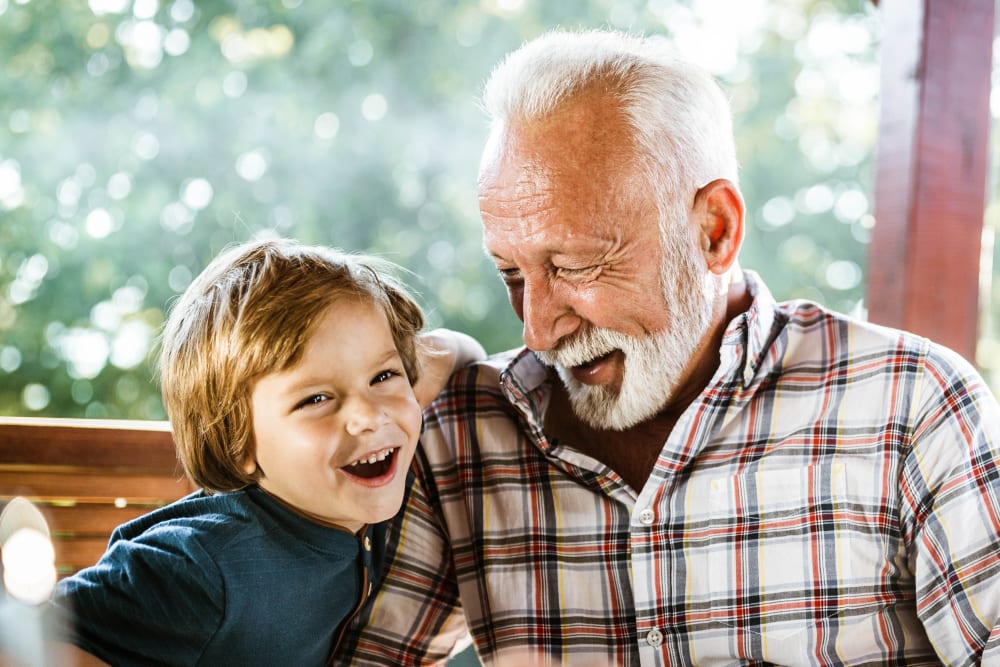 A resident and young boy laughing at Merrill Gardens at Sheldon Park in Eugene, Oregon. 