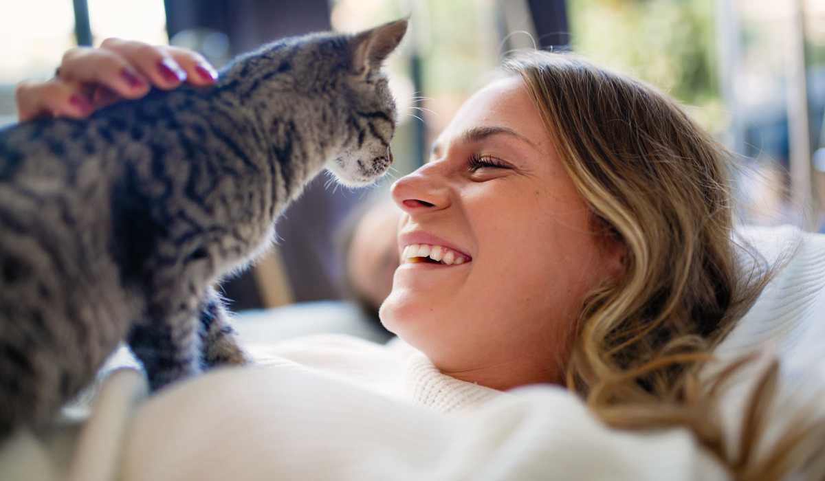 Resident woman with her cute pet cat in living room at The Edison at Madison in Madison, Alabama