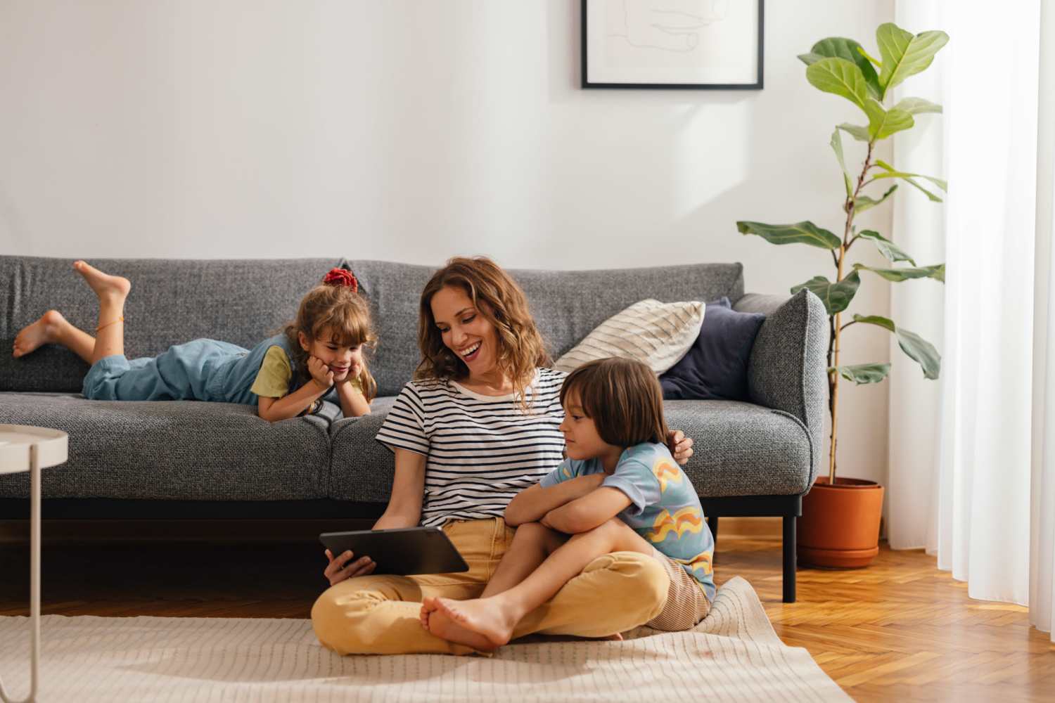 Resident woman with her kids in a living room at Patterson Crossing in Frankfort, Michigan