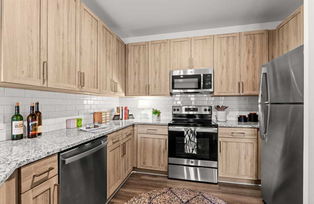 Kitchen with wood cabinet and granite countertop at Watersound Origins Crossings in Inlet Beach, Florida