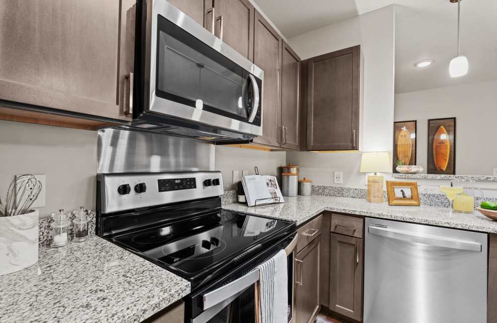 A kitchen with granite countertop and waterfall faucet sink at Pier Park Crossings in Panama City Beach, Florida