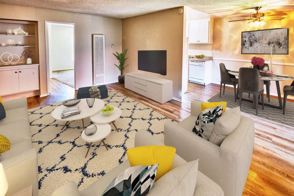 Spacious living room with couch, coffee table and flat screen television at Windwood Apartments in West Covina, California
