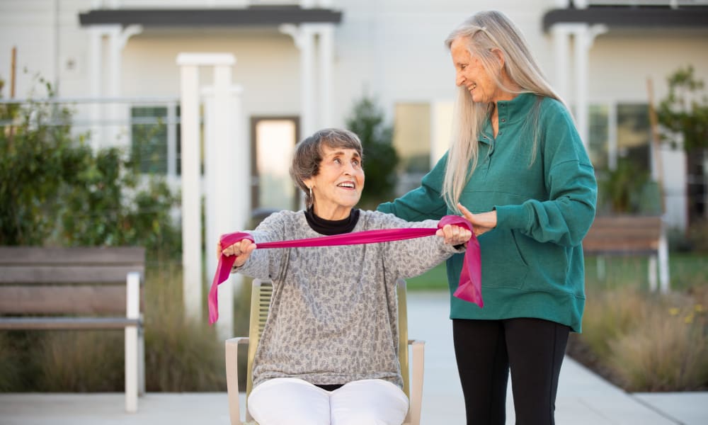 Resident getting help with an exercise band at Clearwater at The Heights in Houston, Texas