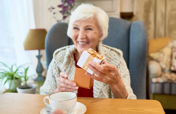 Senior woman opening gift