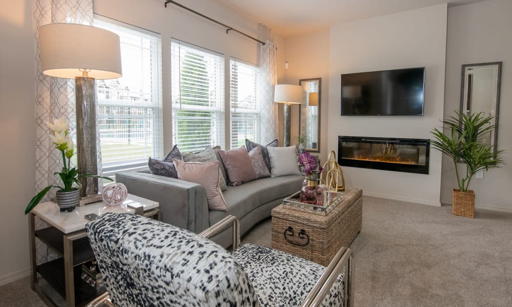 Open and bright model living room with fireplace at Redbud Ranch Apartments in Broken Arrow, Oklahoma