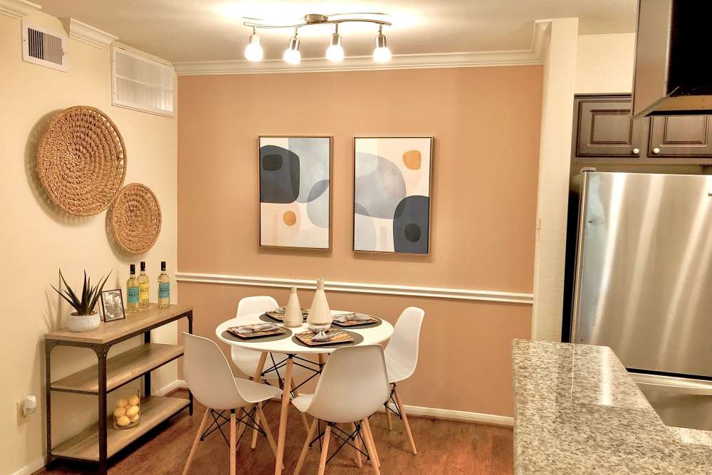 Four seater dinning area with wall art  at The Abbey At Enclave in Houston, Texas