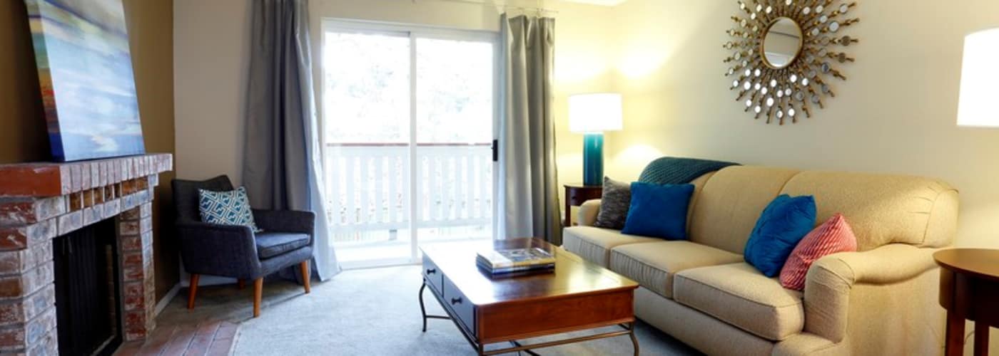 Spacious living room with fireplace and brick mantel at Discovery Landing Apartment Homes in Burien, WA