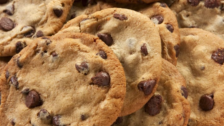 Close-up view of a large stack of baked chocolate chip cookies