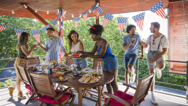 Five friends gathered around a table of food with Independence day decorations everywhere.
